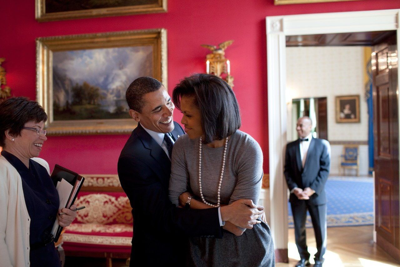 巴拉克 hugs Michelle in the Red Room while Senior Advisor Valerie Jarrett smiles prior to the National Newspaper Publishers Association reception on March 20, 2009. 