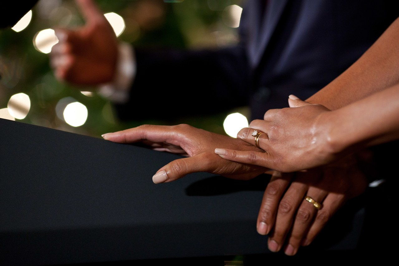 中 one of the Christmas Holiday receptions at the White House, Michelle's hands rest on Barack's hands on the podium as he made brief remarks.