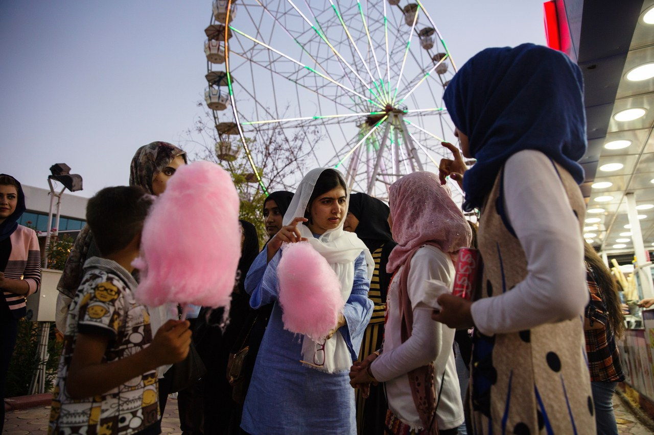 在 Erbil, Malala Yousafzai visits an amusement park with children displaced by ISIS conflict.