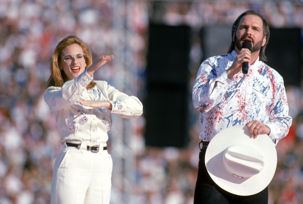 PASADENA, CA - JANUARY 31: Country music star Garth Brooks sings the National Anthem with American sigh language translation preformed by actress Marlee Matlin prior to Super Bowl XXVII between the Dallas Cowboys and the Buffalo Bills at the Rose Bowl on January 31, 1993 in Pasadena, California. The Cowboys defeated the Bills 52-17. (Photo by George Rose/Getty Images)