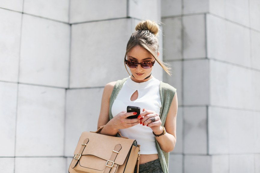 年轻 busy woman using her smart phone