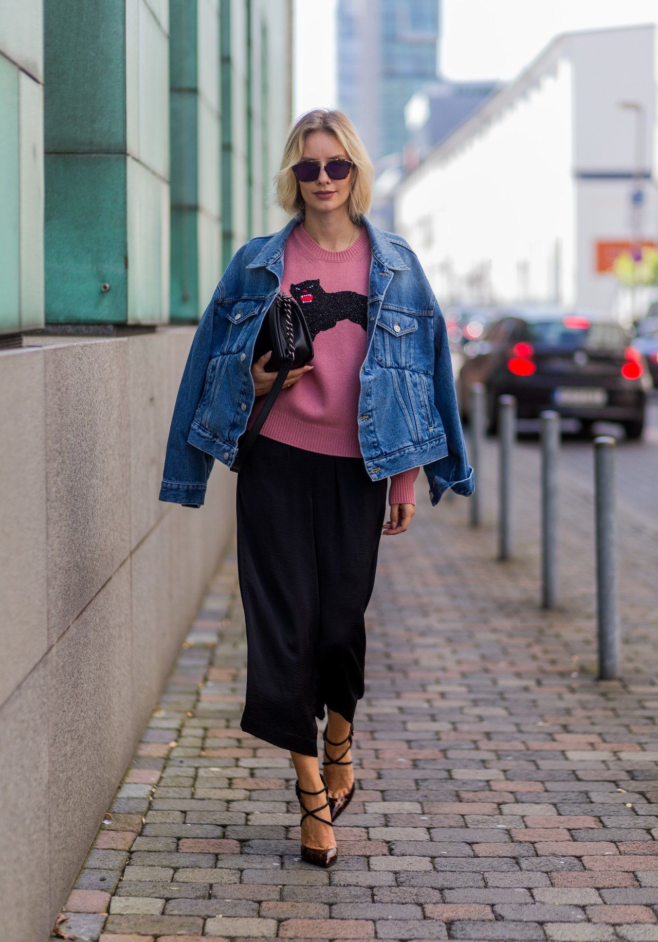 DUESSELDORF, GERMANY - AUGUST 25: Fashion blogger Lisa Hahnbueck (@lisarvd) wearing Dior Abstract sunglasses, blue denim Balenciaga Jeans jacket, a pink Gucci Wool Knit with cat, black Vince Silk Pants, black Christian Louboutin Suzanna High Heels , black Chanel Boy Bag on August 25, 2016 in Duesseldorf, Germany. (Photo by Christian Vierig/Getty Images)